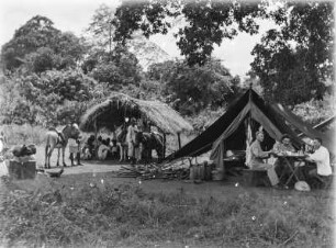 Expeditionslager : Zeltlager der Expedition. Im Vordergrund drei Personen an einem Tisch, ganz links Fritz Techmer.