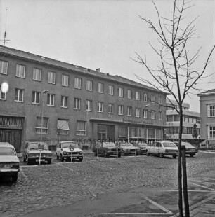 Kreissparkasse Stormarn: Markt: Altbau, mit Firmenname: hinten Neubau Kreissparkassenzentrale in Hagenstraße: hinten rechts Historisches Rathaus, Gänseliesel-Brunnen: Markt mit Kopfsteinpflaster, Parkplätze, Parkuhren, parkende Autos, Straßenlampen: im Vordergrund junger Baum