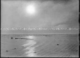 Mitternachtssonne, Spiegelung im leicht gekräuselten Meer, treibende Eisschollen, Nordlandreise, Norwegen
