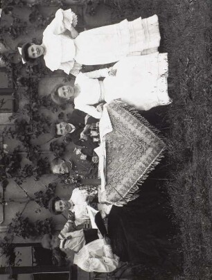 Gruppenbild an einem Tisch vor einem ländlichen Wohnhaus