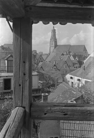 Nördlingen. Stadtteilansicht mit St.-Georgs-Kirche : Nördlingen, Stadtteilansicht. Blick aus einem offenen Gebäudeteil mit Fachwerkkonstruktion nach Nordwesten gegen die evangelische Pfarrkirche St. Georg (1427-1505)