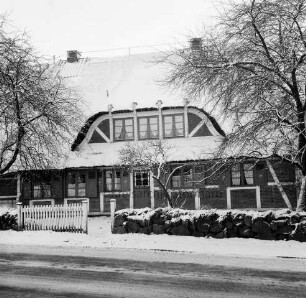 Bauernhof "Bökenhof" mit Fachwerk und Reetdach: davor Feldsteinmauer, Zaun und Bäume: Winter