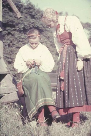 Reisefotos Skandinavien. Frau und häkelndes Mädchen in Tracht