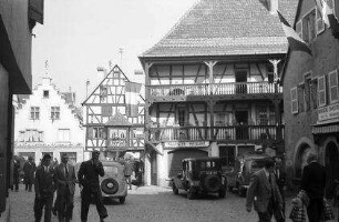 Turckheim: Gasse am Tor und Kirchturm, rechts Fachwerkhaus mit Balkons