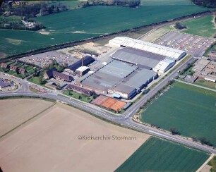 British American Tobacco (BAT): Luftbild des Gewerbegebietes am Beimoorweg: im Vordergrund Beimoorweg, im Hintergrund Bahnstrecke Hamburg-Lübeck