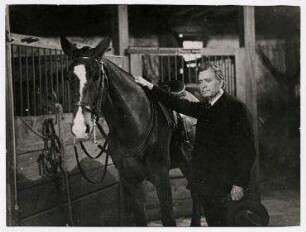 Senator William Borah privat im Stall mit einem Pferd, USA. William Borah