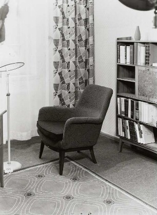 Sessel : Sessel (1956; Sächsische Sitzmöbelwerkstätten Waldheim) vor Gardine und Regal in Ausstellungskoje