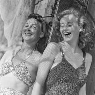 Elisabeth Gremmler (links) und eine Freundin in Bademode im Schatten eines Netzes