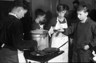 Freiburg: Adelhauser Schule; Jungen lernen Kochen; Jungen am Kochherd beim Pfannkuchenbacken