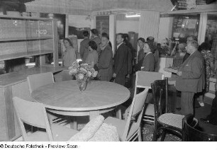 Besucher der Herbstmesse 1953 betrachten Eßzimmereinrichtungen