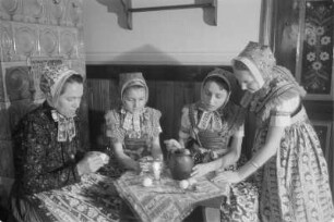 Schleifer Frauen und Mädchen in Schleifer Tracht beim Verzieren von Ostereiern. : Holcy a žony w Slepjanskej drasće při debjenju jutrownych jejkow pola Wěrikec w Rownom.