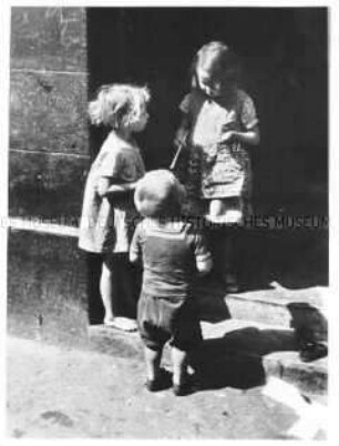 Drei kleinere Kinder im Gespräch