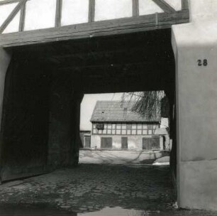 Schönberg-Tettau, Waldenburger Straße 28. Vierseithof (1. H. 19. Jh.). Blick durch das Torhaus gegen Hoffront des Stallgebäudes