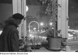 Renate Rössing schaut aus einem Fenster auf den nächtlichen Weihnachtsmarkt