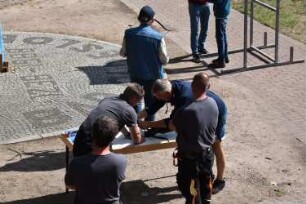 Bad Oldesloe: Kindervogelschießen: Exer: Aufsichtspersonen beim Spannen einer Armbrust: 13. Juli 2023