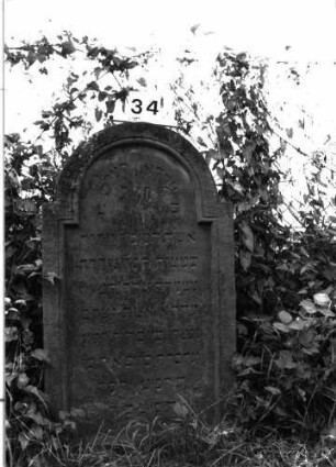 Grabstein 34 (Index: 99891792) Material: Sandstein Zustand: mäßig Maße HxBxT: 116x64x9 cm Beschreibung: rechteckige Stele mit Rundbogenabschluß: Grabstein 34