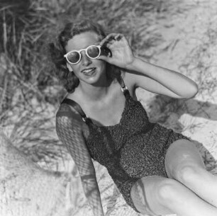 Frau im Bikini mit Sonnenbrille am Strand
