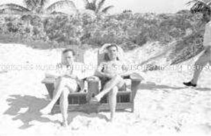 Zwei Touristen in Liegestühlen am Strand