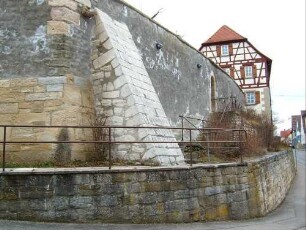 Ansicht von Südwesten über Kirchhofmauer (im Basisbereich als Futtermauer) mit eckständigem Strebepfeiler im Detail