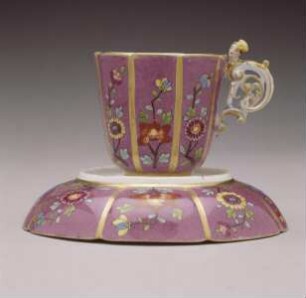 Henkeltasse und Unterschale mit Purpurfond, Blumendekor und Frauenkopf-Henkel