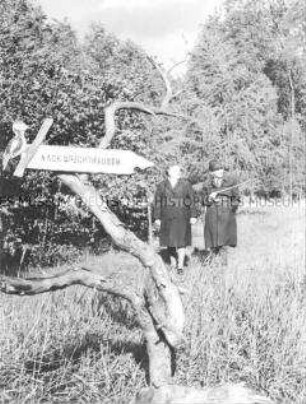 Älteres Ehepaar vor selbstgemachtem Wegweiser der Mitglieder der AG Junger Gartenbauer der Station Junger Techniker und Naturforscher Eberswalde