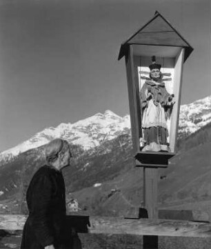 Stubaital : Alte Frau neben einem Bildstock mit Heiligenfigur im Stubaital