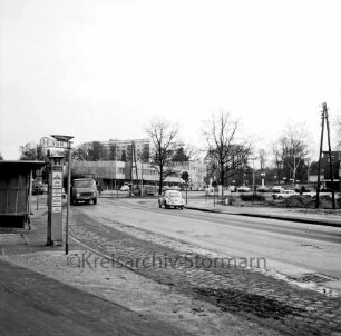 Möllner Landstraße: vorn links Bushaltestelle: Lastwagen und Pkw: hinten rechts Abzweigung der Bahnhofstraße: dahinter Oher Weg: Geschäftsgebäude: dahinter Wohnblock