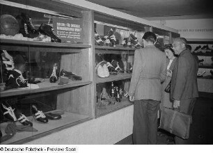 Fachbesucher vor Vitrinen mit Sportschuhen