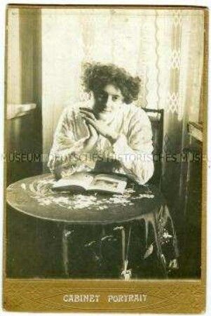 Florentine Fleischhut mit einem Buch am Tisch sitzend