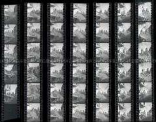 Schwarz-Weiß-Negative mit Aufnahmen von Erntehelferinnen an der Dreschmaschine