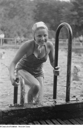 Portrait eines Mädchens in Badebekleidung aus dem Becken steigend, Bad Süd-Ost in der Oststraße