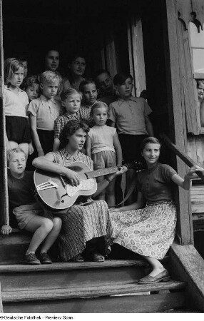 Kinder beim Singen mit Betreuerin im Hauseingang der Alten Winkelmühle