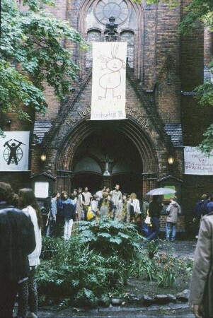 DDR. Berlin-Lichtenberg. Erlöserkirche (1892). Westportal mit Mitgliedern und Transparenten der Friedensbewegung zur 4. Friedenswerkstatt 1985