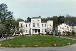 Gut Wulksfelde: ehemaliges Herrenhaus: Straßenfront mit Mittelrisalit, Freitreppe, Vorbau mit eingezogenem Eingangsportal, darüber Altan, zwei Eckrisalite: beiderseits Kavalierhäuser mit verglasten Eingangsveranden: vorne Vorplatz, junge Bäume, Auffahrt: 9. Mai 2003