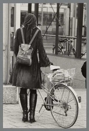 Rückansicht einer jungen Frau mit Fahrrad