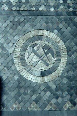Detail Hauswand: Handwerksutensilien des Schieferdeckers