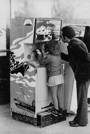 Mann mit Mädchen an einem Spielautomaten