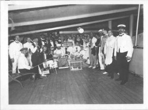 Hochseepassagierdampfer Cleveland, Bordaufnahmen. Gruppenbild mit kostümierten Touristen und Katzen in Tierkäfigen während eines Bordfestes