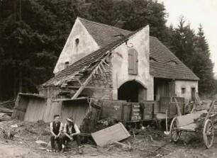 Unwetterkatastrophe im Osterzgebirge am 8./9. Juli 1927. Müglitztal. Schwer beschädigte Gebäude mit angetriebenen Güterwagen der Schmalspurbahn