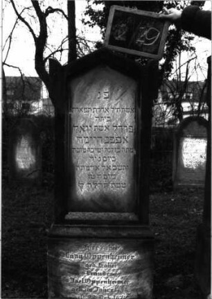 Grabstein 57 (Index: 99804789) Material: Sandstein Zustand: vor allem Sockel verwittert Maße HxBxT: 132x53x22 cm Beschreibung: Stele, Sockel, giebelartiger Abschluß mit Ohren: Grabstein 2/29