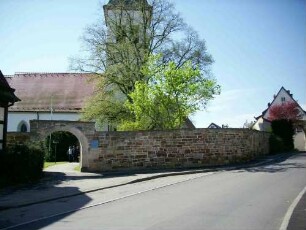 Ansicht von Norden mit Kirche (im Kern Gotisch - 1840 renoviert) über Kirchhofmauer (Wehrgang mit Steinbrüstung sowie Toranlage im 18 Jh abgetragen)