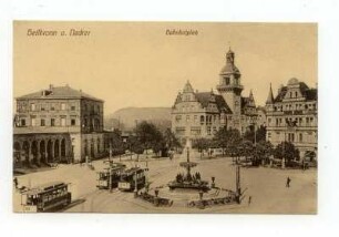 "Bahnhofplatz" - Hauptbahnhof (angeschnitten), Bahnhofvorplatz mit Löwenbrunnen, Postamt 2, Hotel Royal, Straßenbahnen, im Hintergrund Wartberg