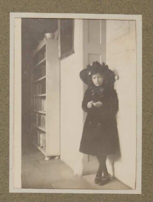Christiane von Hofmannsthal im dunklen Kleid mit Hut an der Rodauner Salontür lehnend
