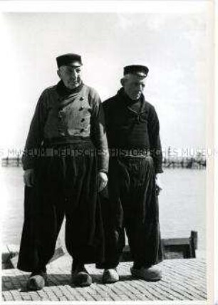 Holland, Volendam, zwei Männer in tradioneller Kleidung am Hafen