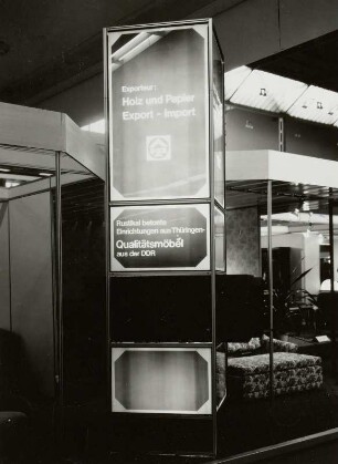 Leipzig. Leipziger Herbstmesse, 1983. Raumaufnahme mit Leuchtsäule für Holz und Papier - Export - Import