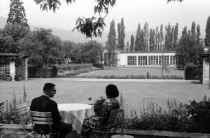 Bad Dürkheim: Im Kurpark, Kurmittelhaus, Vordergrund zwei Personen am Tisch