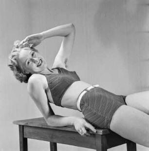 Frau im Bikini liegt auf einem Tisch