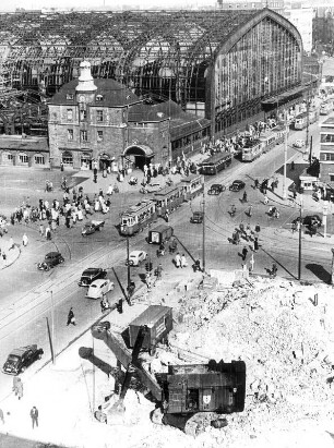 Hamburg-Mitte. Ansicht der Kreuzung Steintorwall/Mönckebergstraße 1950. Trümmer werden beseitigt. Im Hintergrund der teilweise zerstörte Hauptbahnhof. Auf den Straßen herscht emsiges Treiben
