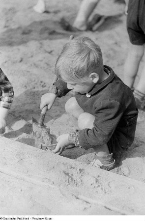 Kleiner Junge, im Sand spielend