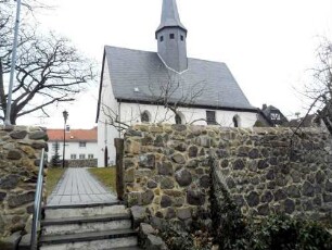 Krofdorf-Evangelische Kirche - Ansicht von Süden mit Kirche (Spätromanische Gründung 13 Jh) über Kirchhofmauer (Wehrgang mit Steinbrüstung und Schießscharten abgetragen)